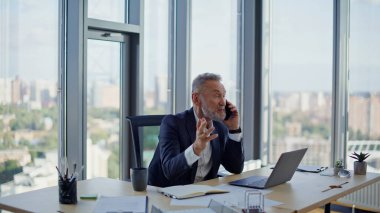 Şirket işyerinde kıdemli bir çalışan akıllı telefona gülüyor. Mutlu gri saçlı işadamı cep telefonu konuşmalarıyla iş başarısını paylaşıyor. Neşeli yönetici ofisteki dostça telefon iletişiminin keyfini çıkarıyor.