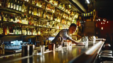 Gece atmosferinde tezgahı silen bir bar işçisi. Resmi olarak kendine güvenen barista modern gece kulübünün dinlenme odasında temiz yüzey giyer. Parti barında çalışan odaklanmış bir garson. Yaratıcı işgal kavramı