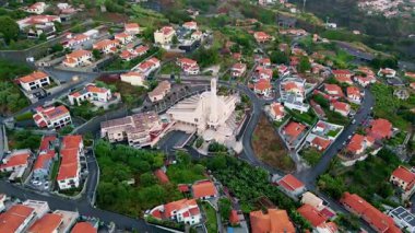 Panorama beautiful Portuguese city district aerial view. Winding street surrounded by red roofs. Houses spreading on hilly terrain in organized settlement. Cozy urban neighborhood covered greenery.