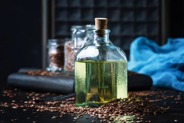 ガラス瓶や種子 暗い背景の選択と集中に亜麻仁油または亜麻油 — ストック写真