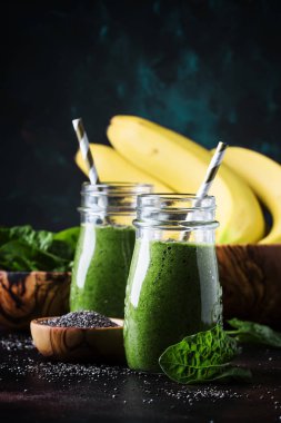 Ispanak, muz ve chia tohumu, kahverengi zemin, seçici odak ile yeşil smoothies