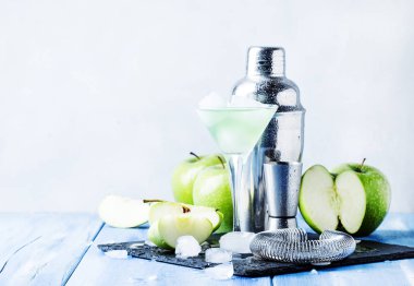 Alkollü kokteyl yeşil elma ve kuru vermut, şurup, limon suyu ve buz küpleri ile. Taş arka plan, seçici odak araçları, gri