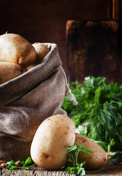 Φρέσκα Ωμά Πατάτες Μια Τσάντα Καμβά Ξύλινο Υπόβαθρο Ρουστίκ Στιλ — Φωτογραφία Αρχείου