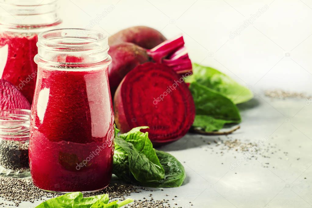 Healthy and healthy detox smoothies or juice from raw beets and spinach with chia seeds in glass bottles on a gray background, selective focus