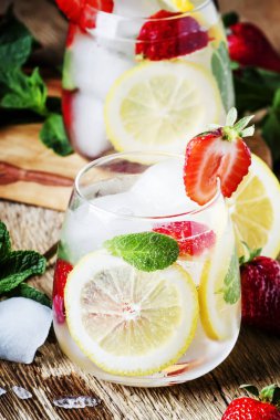 Alkolsüz kokteyl çilek, nane, limon, soda ve buz, eski ahşap arka plan, seçici odak ile