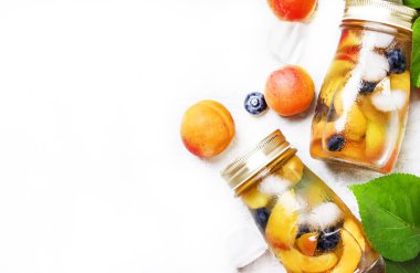 Yaz soğuk içecek. Kayısı, yaban mersini ve buz, gri arka plan, üstten görünüm ile buzlu çay