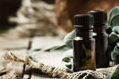 Antika ahşap blackground, rustik tarzı, seçici odak kahverengi şişede temel adaçayı yağı