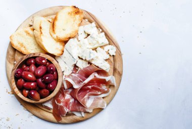 Mezeler, crostini, prosciutto, mavi peynir ve zeytin, gri arka plan, üstten görünüm ile kurulu 