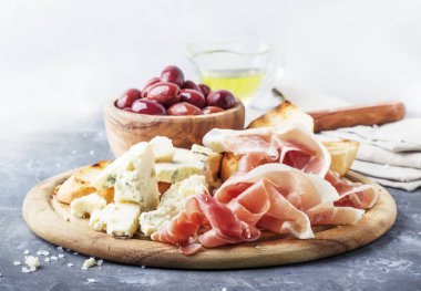 Mezeler, crostini, prosciutto, mavi peynir ve zeytin, gri arka plan, üstten görünüm ile kurulu 