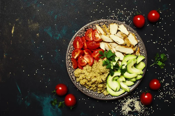 Healthy food, avocado, quinoa, chicken and tomatoes on plate, top view