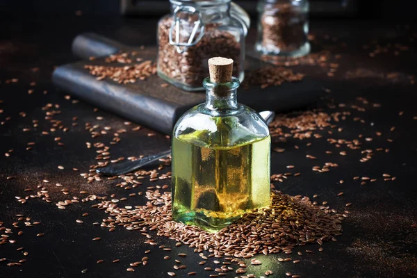 Linen or flax cold pressed oil in bottle, rustic style, vintage background, selective focus