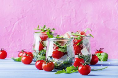 Yaz salatası roka, yumuşak peynir, domates ve prosciutto cam kavanozlar, Festival arka plan, seçici odak