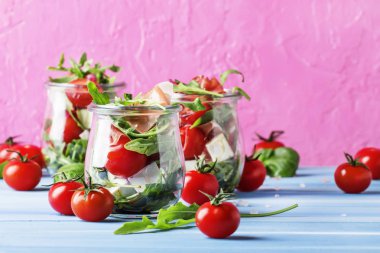 Yaz salatası roka, yumuşak peynir, domates ve prosciutto cam kavanozlar, Festival arka plan, seçici odak