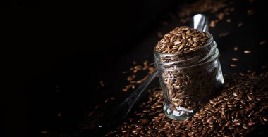 Keten veya kahverengi taş zemin, seçici odak üzerinde kavanoza keten tohumu