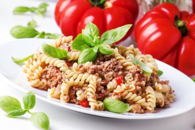 Domates ve fesleğen beyaz plaka, seçici odak üzerinde et sos ile hazırlanmış makarna