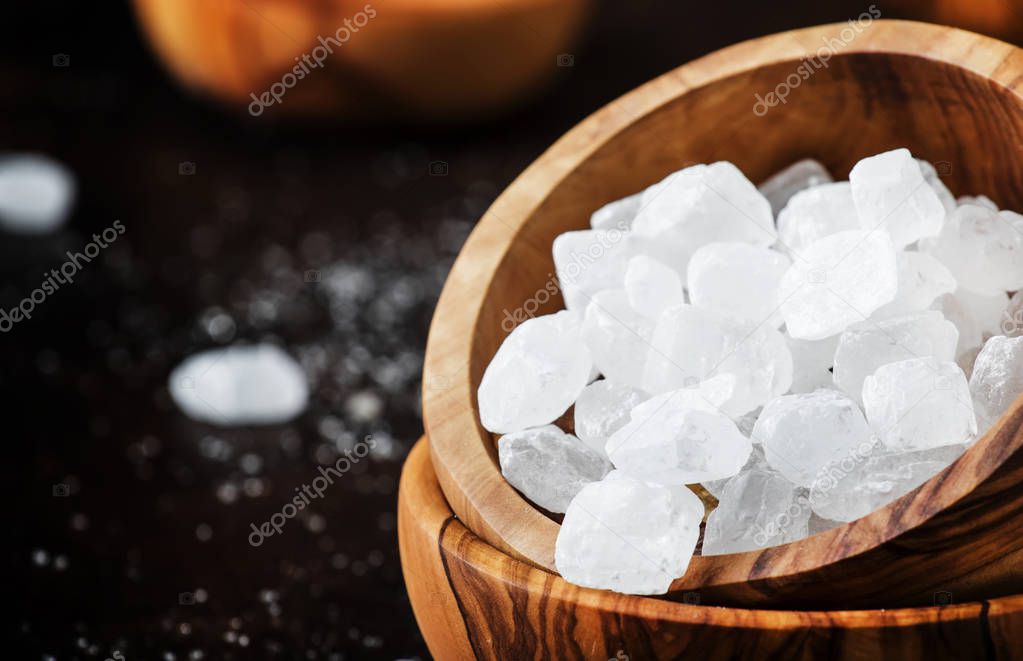 White crystal candy sugar, brown background, selective focus