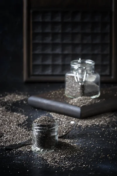 小さなガラスの瓶 灰色の背景 選択と集中でチア種子 — ストック写真