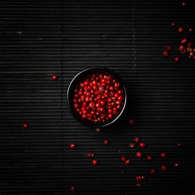 Pembe gül biber kase, siyah arka plan, üstten görünüm