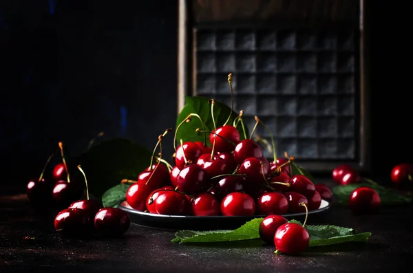 Red sweet cherries on brown table, selective focus