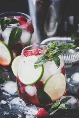 Yaz serin alkollü kokteyl ahududu mojito kireç, ROM, nane ve buz ile kokteyl. Bar araçları, gri arka plan, seçici odak