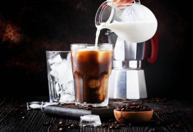 Yaz soğuk kahve buz ve süt, kahverengi zemin, seçici odak ve sığ Dof