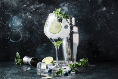 Yaz alkollü kokteyl böğürtlenli mojito ROM, nane, limon ve buz, Araçlar, gri arka plan, seçici odak bar