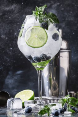 Yaz alkollü kokteyl böğürtlenli mojito ROM, nane, limon ve buz, Araçlar, gri arka plan, seçici odak bar