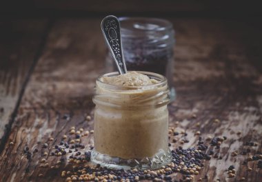 Bir cam kavanoz ve tohumlar siyah ve sarı hardal hardal rustik tarzı eski ahşap masa