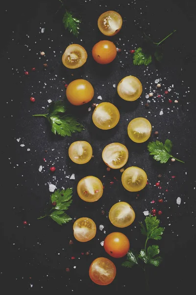 暗い背景に食品背景 黄色ミニトマトの半分 スパイスします — ストック写真