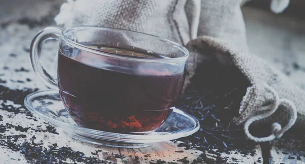 Glas Genomskinlig Kopp Svart Och Torr Påsar Bakgrunden Spridda Teblad — Stockfoto