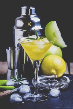 Kuru vermut, şurup, limon suyu, yeşil elma, biberiye ve buz küpleri ile alkollü kokteyl elmalı martini. Araçlar siyah arka plan