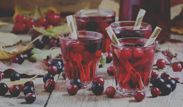 Autumn drink with cranberry and aronia on wooden table