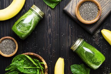 İnanılmaz faydalı yeşil ıspanak smoothies ile chia sarı muz, üstten görünüm ahşap zemin üzerine cam şişelerde