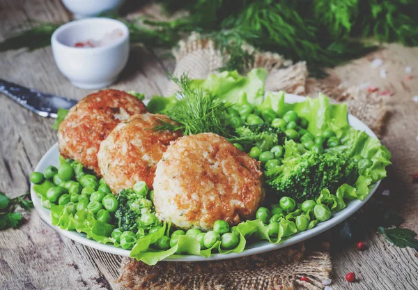 Balık pirzola veya cod ve pike köfte yeşil bezelye ve brokoli, rustik tarzı, seçici odak bir garnitür ile levrek