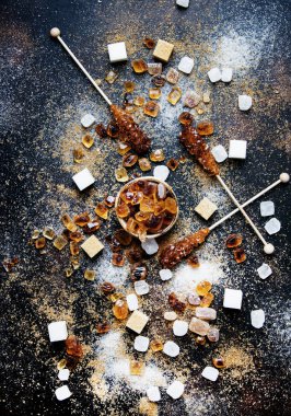 Tatlı gıda arka plan, karanlık bir arka plan, üstten görünüm üzerinde çeşitli beyaz ve kahverengi şeker