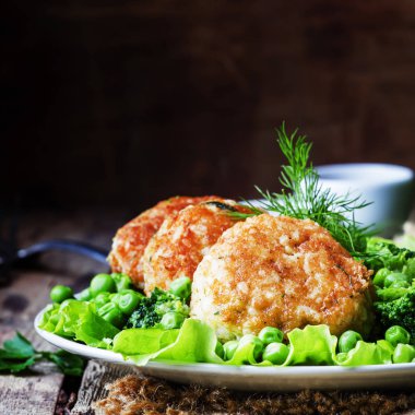 Balık pirzola veya cod ve pike köfte yeşil bezelye ve brokoli, rustik tarzı, seçici odak bir garnitür ile levrek