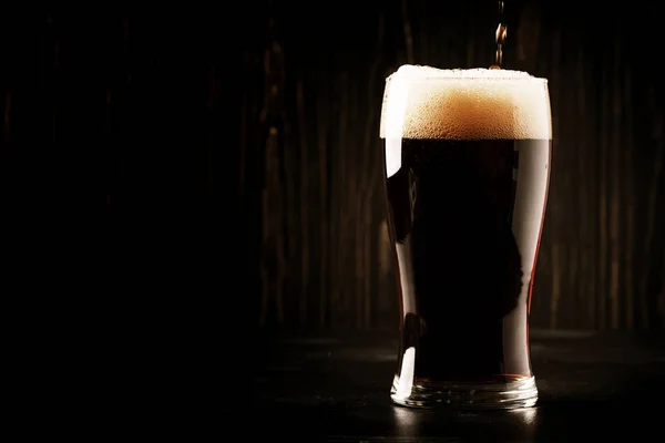 英国産ビール エールやスタウトに注がれていますガラス バーカウンターでは 暗いテキスト 選択と集中のためのスペース — ストック写真