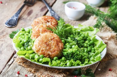 Balık pirzola veya cod ve pike köfte yeşil bezelye ve brokoli, rustik tarzı, seçici odak bir garnitür ile levrek