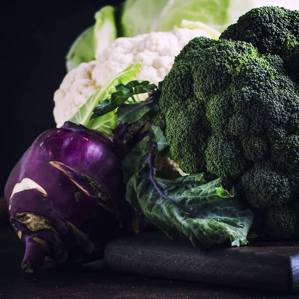 Different kinds of cabbage such as white cabbage, cauliflower, broccoli, kohlrabi on dark table, autumn harvest, selective focus — Stock Image Different Kinds Cabbage White Cabbage Cauliflower Broccoli Kohlrabi Dark Table Stock Photo