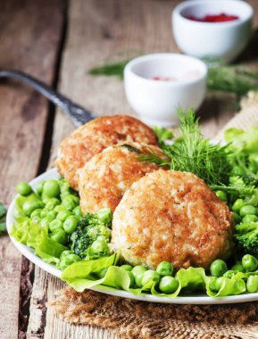 Balık pirzola veya cod ve pike köfte yeşil bezelye ve brokoli, rustik tarzı, seçici odak bir garnitür ile levrek