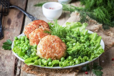 Balık pirzola veya cod ve pike köfte yeşil bezelye ve brokoli, rustik tarzı, seçici odak bir garnitür ile levrek