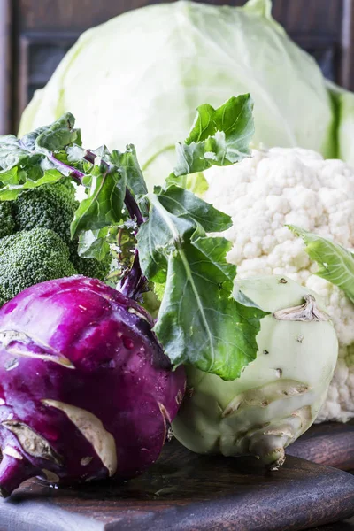 Different kinds of cabbage such as white cabbage, cauliflower, broccoli, kohlrabi on dark table, autumn harvest, selective focus — Stock Image Different Kinds Cabbage White Cabbage Cauliflower Broccoli Kohlrabi Dark Table Royalty Free Stock Photos