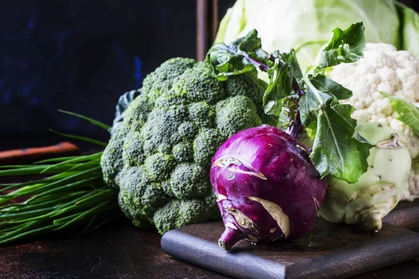 Different kinds of cabbage such as white cabbage, cauliflower, broccoli, kohlrabi on dark table, autumn harvest, selective focus — Stock Image Different Kinds Cabbage White Cabbage Cauliflower Broccoli Kohlrabi Dark Table Royalty Free Stock Photos