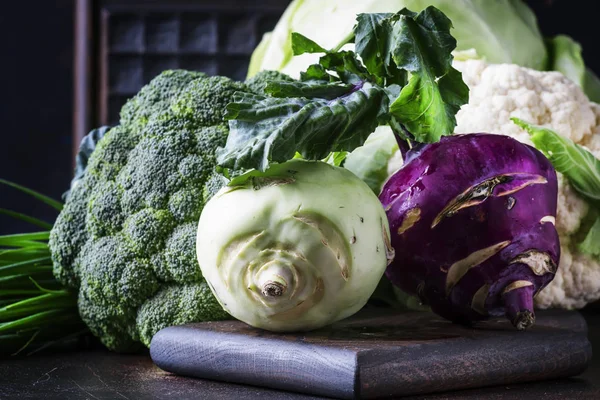 Different kinds of cabbage such as white cabbage, cauliflower, broccoli, kohlrabi on dark table, autumn harvest, selective focus — Stock Image Different Kinds Cabbage White Cabbage Cauliflower Broccoli Kohlrabi Dark Table Royalty Free Stock Photos