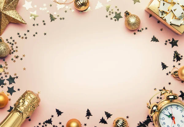 Noel ve yeni yıl kompozisyon, çerçeve, altın Noel süsleri, yıldız, kar taneleri, topları, çalar saat, hediye kutusu ve şişe şampanya, en iyi görünümü ile pembe arka plan