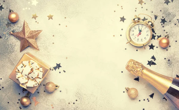 Noel ve yeni yıl kompozisyon, çerçeve, altın Noel süsleri, yıldız, kar taneleri, topları, çalar saat, hediye kutusu ve şişe şampanya, en iyi görünümü gri arka plan