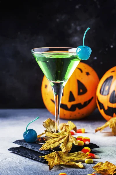 お祝い飲み物 緑のカクテルとカボチャのランタン 夜暗い青色の背景は 選択と集中に落ちた葉のハロウィーンのコンポジション — ストック写真
