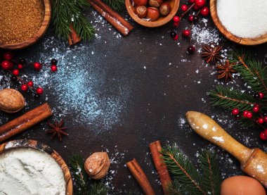 Yeşil çam dalları, fındık, anason ve tarçın mavi kahverengi zemin, çerçeve, üstten görünüm ile pişirme için malzemeler ile Noel ve yeni yıl kompozisyon