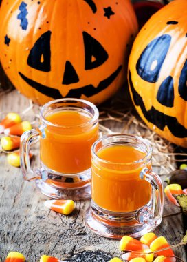 Cadılar Bayramı turuncu şenlikli içki tatlı Mısır, düşen yapraklar ve saman, seçici odak vintage ahşap sonbahar zemin üzerine 