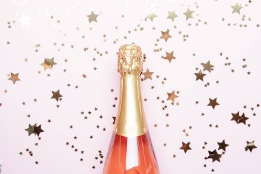 Noel ve yeni yıl pembe arka plan şişe köpüklü şarap, gül şampanya ve altın dekor, üstten görünüm